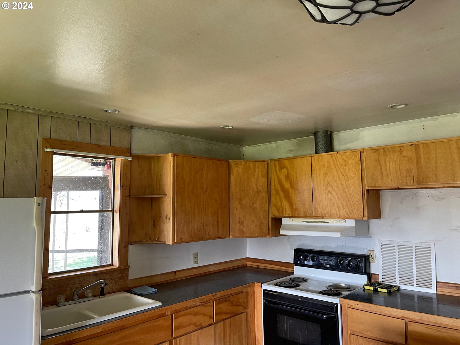 242 Van Hoy Road Goldendale, WA 98620 - Photo 21 of 44 a kitchen with a sink appliances cabinets and a window