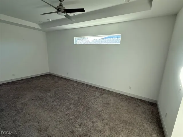 an empty room with a ceiling fan and window