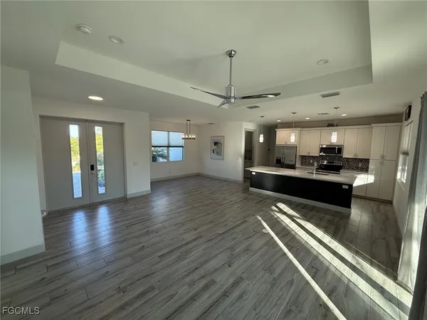 a view of a living room and kitchen with stainless steel appliances