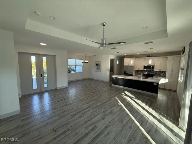 a view of a living room and kitchen with stainless steel appliances