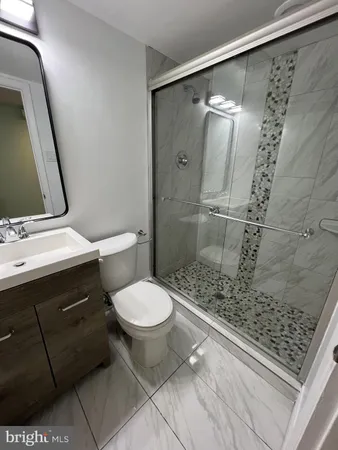 a bathroom with a granite countertop sink toilet and shower