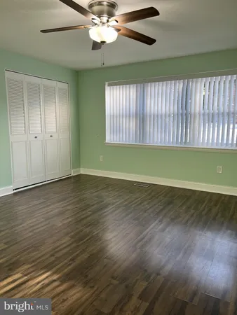 a view of a room with wooden floor and fan