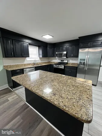 a kitchen with kitchen island granite countertop a sink and counter top space