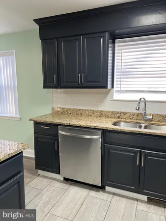 a kitchen with granite countertop cabinets sink and window