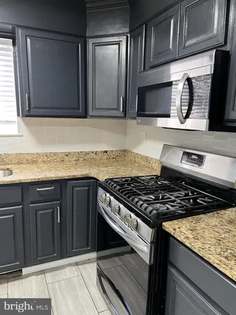 a kitchen with granite countertop stainless steel appliances and cabinets