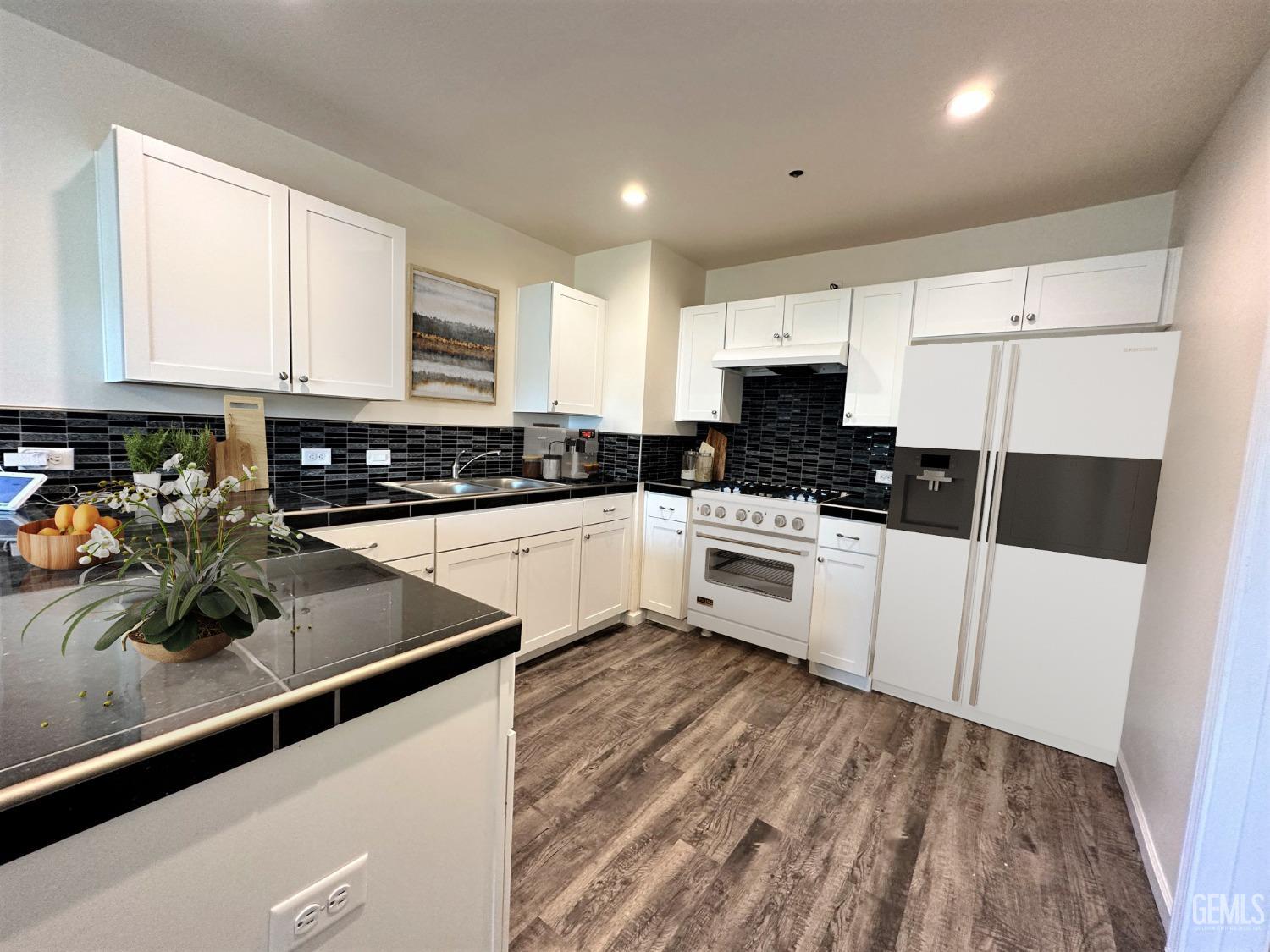 Undisclosed Address Bakersfield, CA 93307 - Photo 4 of 10 a kitchen with sink a microwave and cabinets