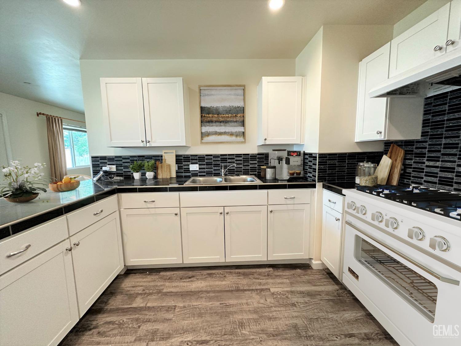 Undisclosed Address Bakersfield, CA 93307 - Photo 5 of 10 a kitchen with granite countertop white cabinets and white appliances
