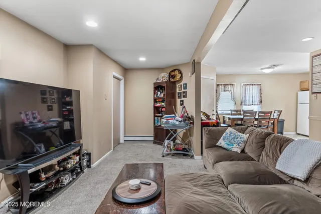 a living room with furniture a flat screen tv and a window