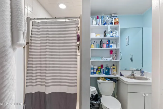 a bathroom with a sink a toilet and a shower curtain