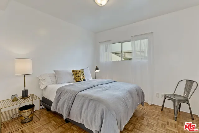 a bedroom with a bed and a large window