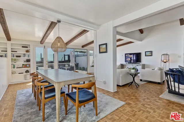 a spacious bedroom with a bed a mirror and a table with wooden floor