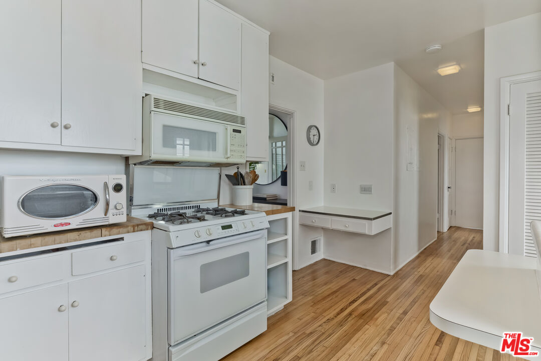 23350 Malibu Colony Road, Unit 109 Malibu, CA 90265 - Photo 44 of 61 a kitchen with white cabinets and white appliances
