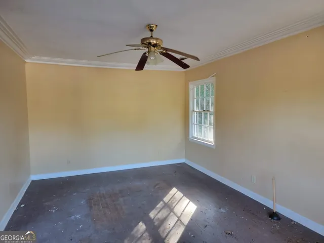 a view of a room with a ceiling fan and window