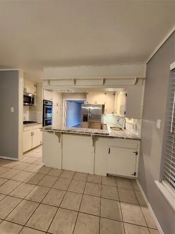 a kitchen with white cabinets a sink and appliances
