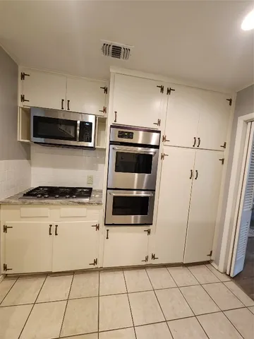 a kitchen with cabinets and steel stainless steel appliances