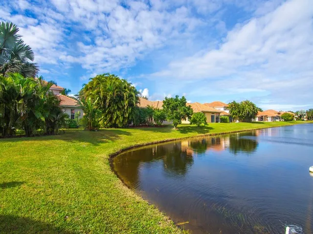 a front view of a house with a yard and palm trees