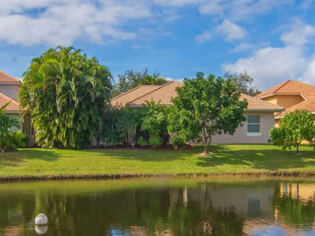 an aerial view of a house with a garden and lake view