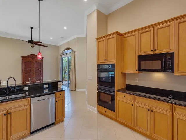 a kitchen with granite countertop a sink stainless steel appliances and cabinets