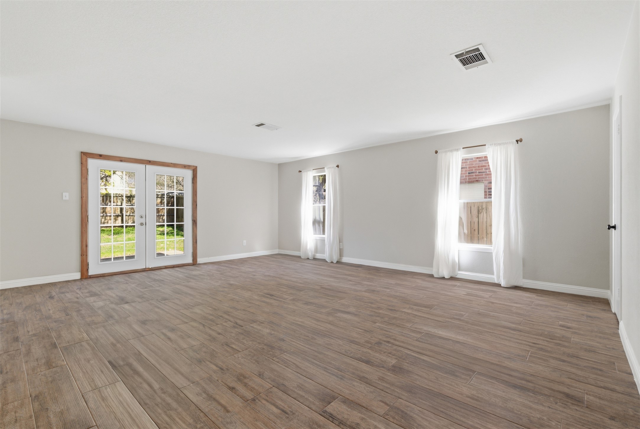 1715 Ruthie Run Cedar Park, TX 78613 - Photo 7 of 25 Open concept living room, with French doors to back yard. Natural light and wood tile flooring compliment the space .