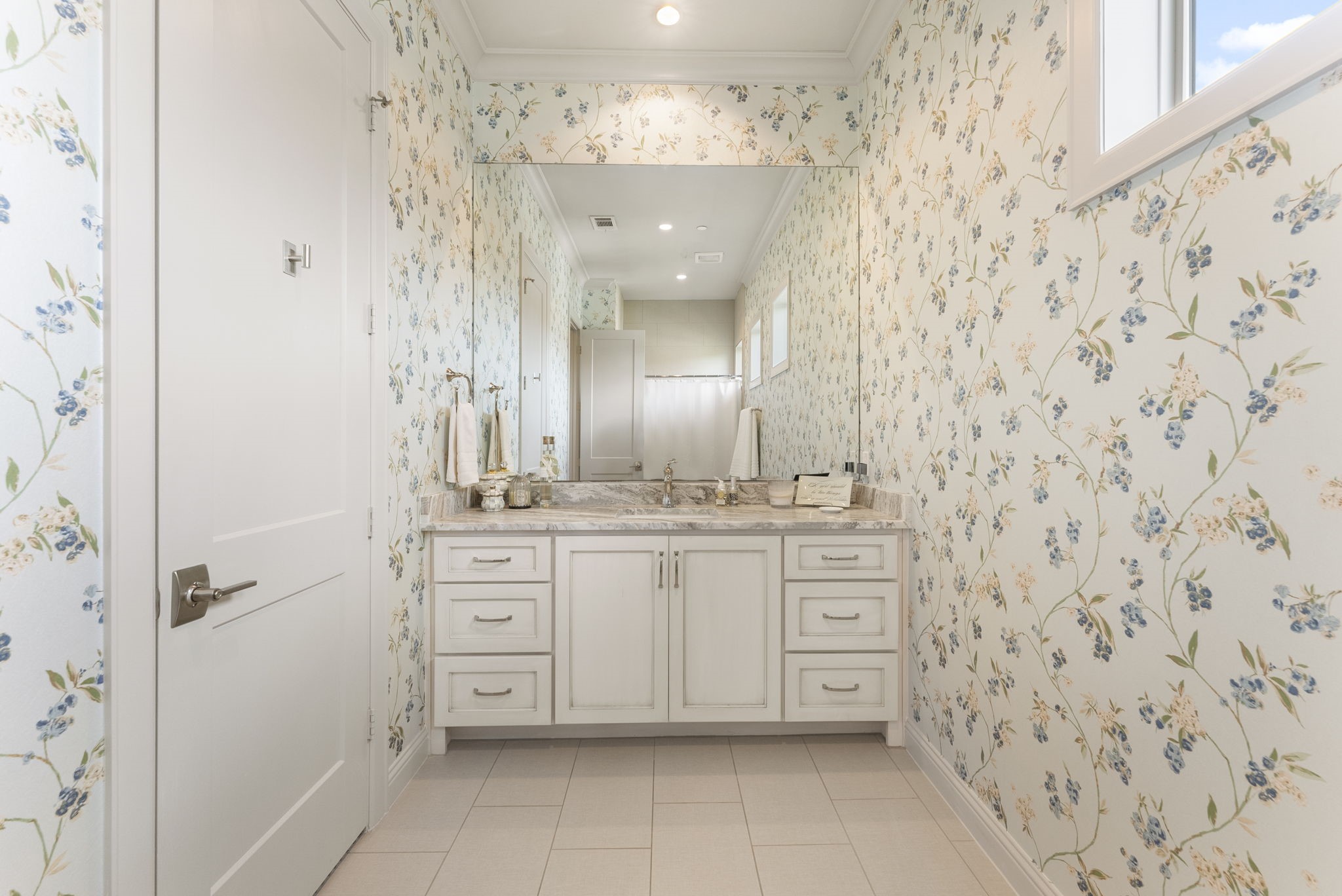 10 Nautical Terrace Way The Woodlands, TX 77380 - Photo 24 of 28 Fourth-floor bath shared by both guest bedrooms, featuring delicate floral wallpaper, a stone-topped vanity with abundant drawers, a separate bathing area and a clerestory window for natural light.