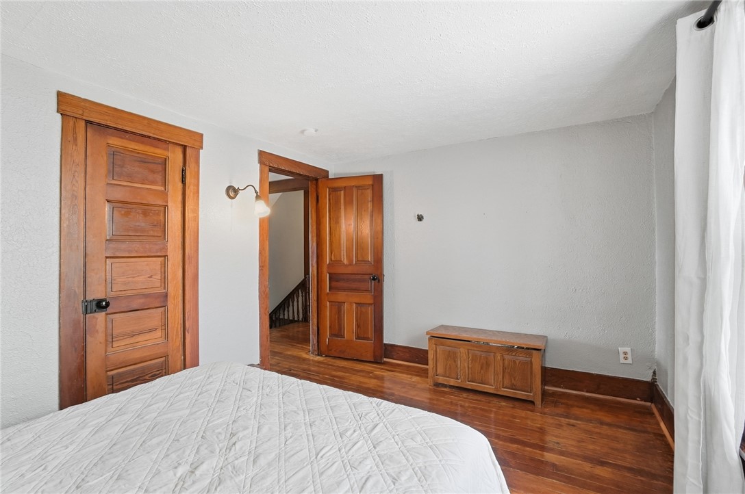 6155 North Union Road Clayton, OH 45315 - Photo 40 of 59 This cozy bedroom features polished hardwood flooring and natural wood doors, creating a warm and inviting atmosphere.