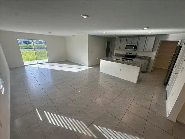 a kitchen with stainless steel appliances a refrigerator sink stove microwave and cabinets