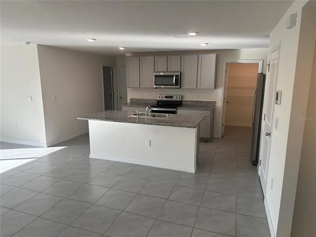 a kitchen with a sink a stove a refrigerator a microwave and cabinets