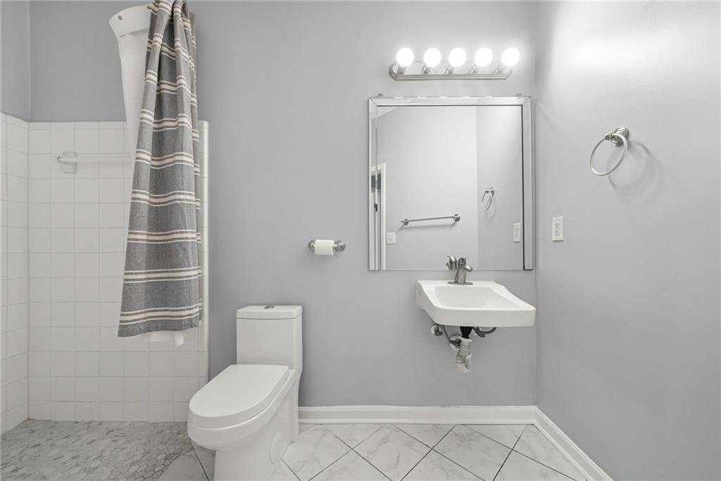 10 Perimeter Summit Boulevard, Unit 3107 Atlanta, GA 30319 - Photo 12 of 44 a bathroom with a sink a toilet and shower