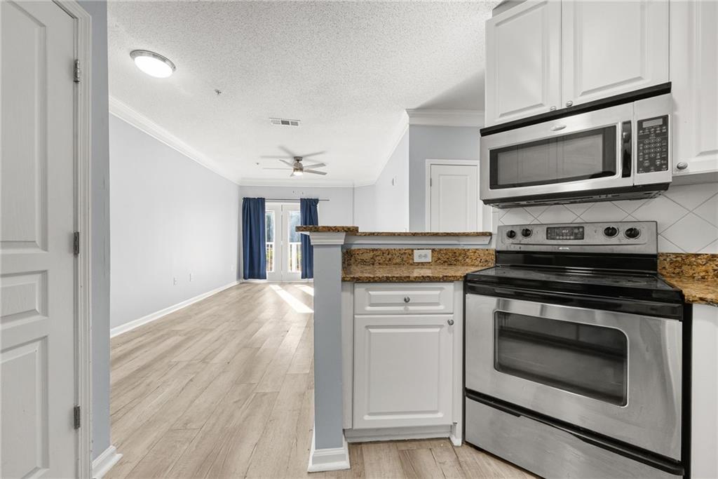 10 Perimeter Summit Boulevard, Unit 3107 Atlanta, GA 30319 - Photo 6 of 44 a kitchen with stainless steel appliances a stove microwave and cabinets