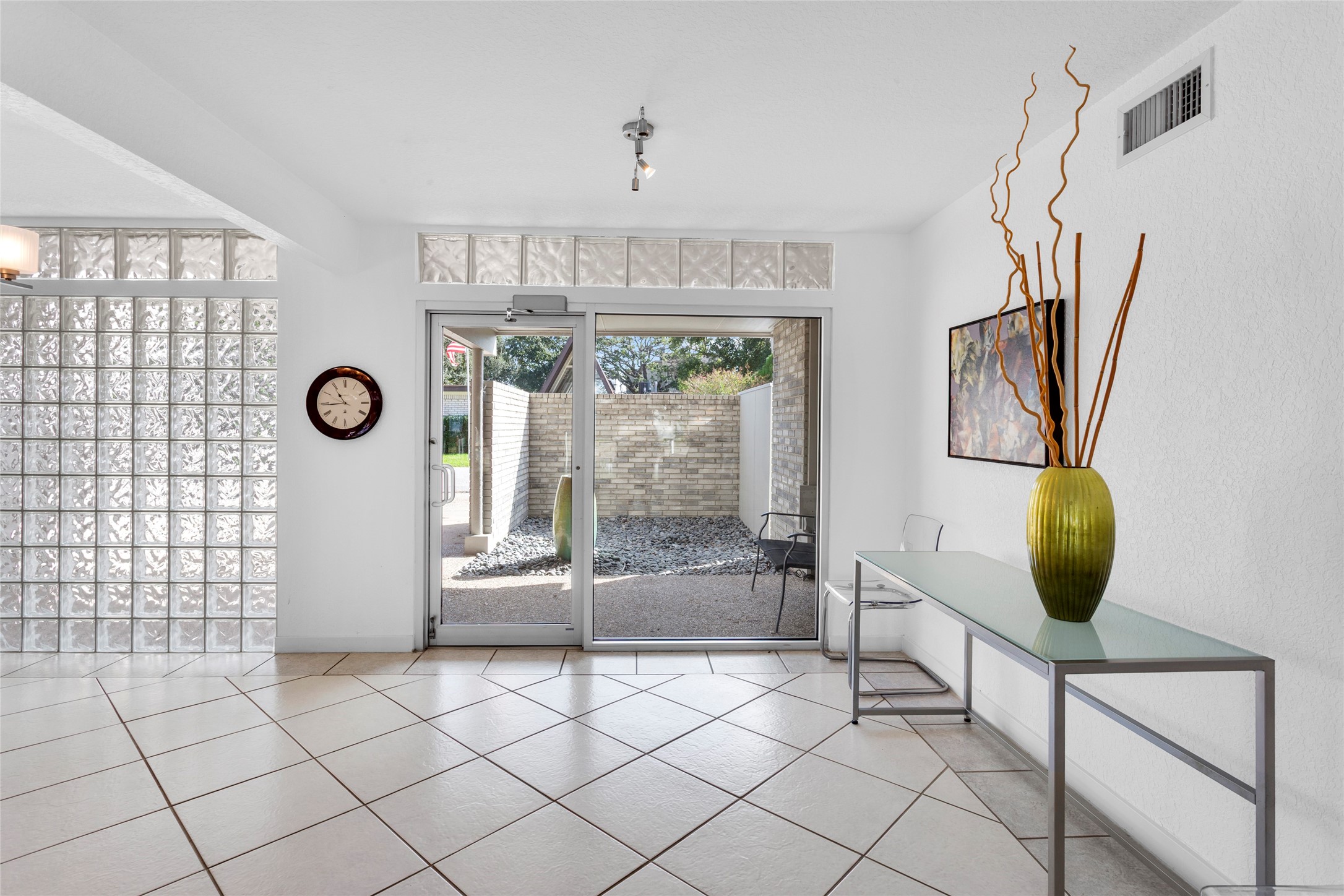 67 Harbor Lane Kemah, TX 77565 - Photo 26 of 47 Bright, modern space with large tile flooring, glass block accents, and a glass door leading to a private outdoor area.