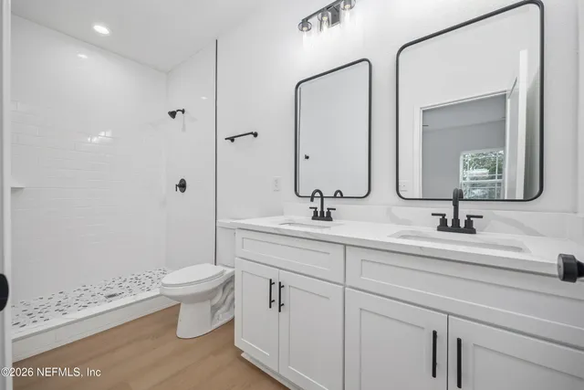 a bathroom with a double vanity sink mirror and toilet