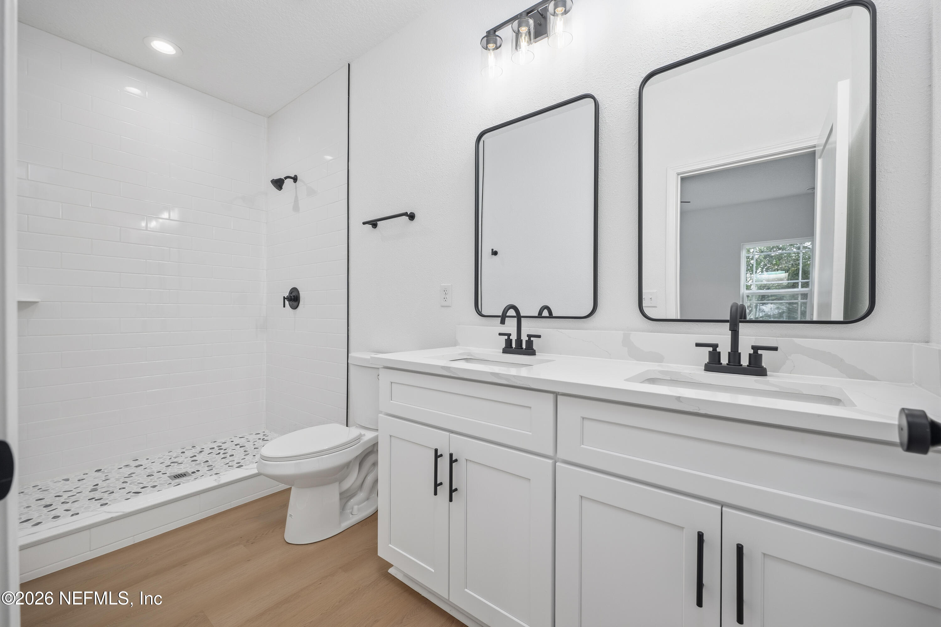 7596 Silver Sands Road Keystone Heights, FL 32656 - Photo 13 of 26 a bathroom with a double vanity sink mirror and toilet