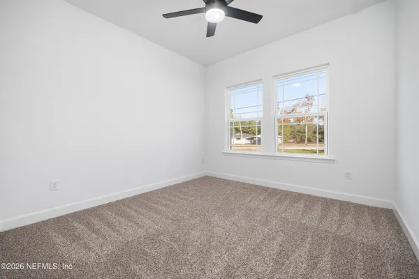 an empty room with a window and a fan