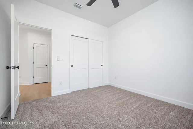 an empty room with a window and a fan