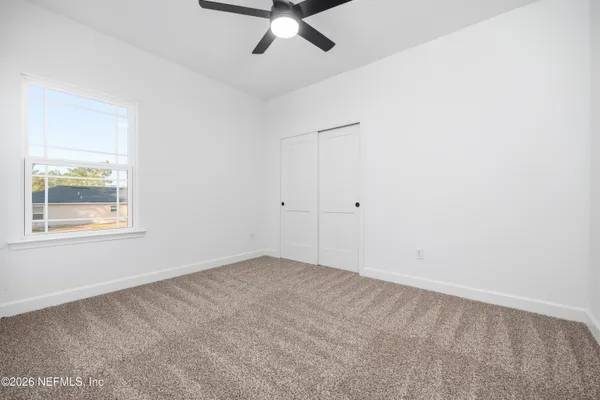 an empty room with chandelier fan