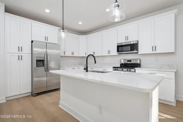 a kitchen with stainless steel appliances a refrigerator sink and cabinets