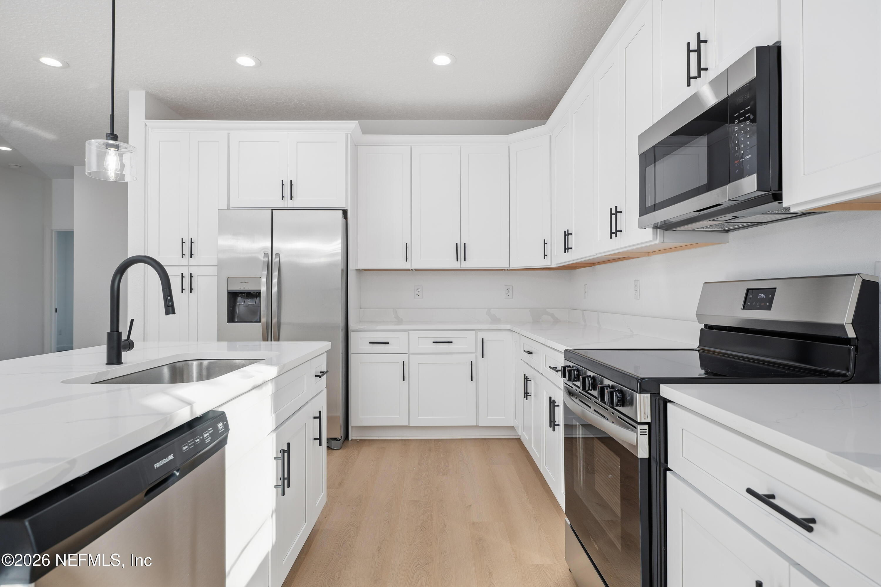 7596 Silver Sands Road Keystone Heights, FL 32656 - Photo 6 of 26 a kitchen with stainless steel appliances a stove microwave and sink