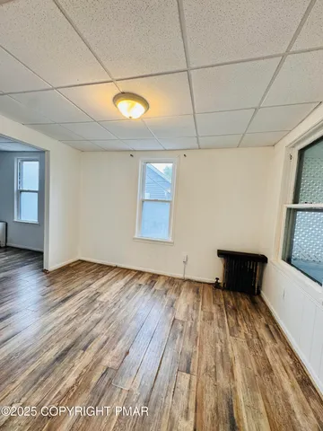 a view of empty room with wooden floor