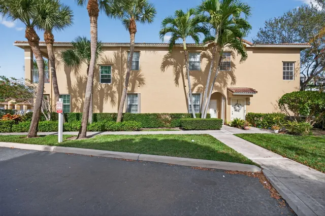 a view of a house with a yard and a palm tree