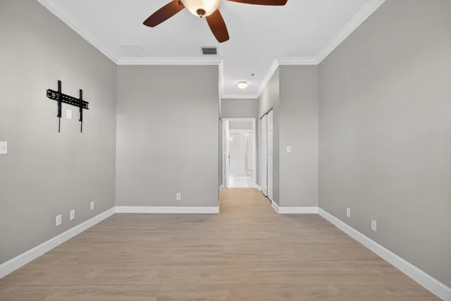 an empty room with closet and a ceiling fan