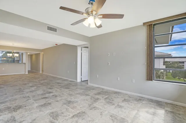 en empty room with windows and chandelier