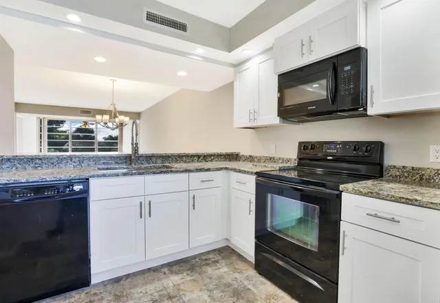 a kitchen with granite countertop a sink and a stove