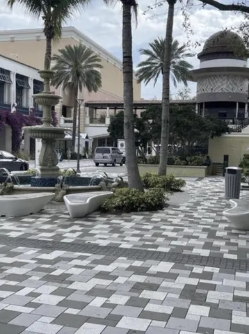 a front view of a building with entryway and palm trees