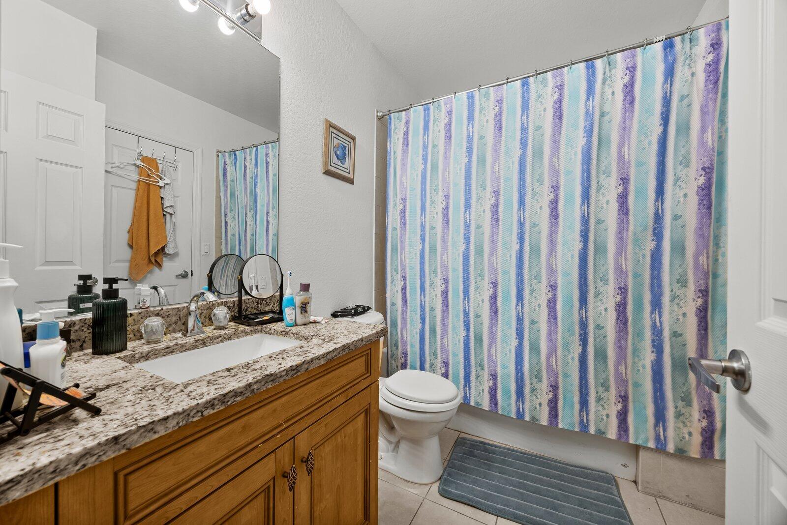 1955 Alamanda Way Riviera Beach, FL 33404 - Photo 13 of 25 a bathroom with a granite countertop toilet sink and mirror