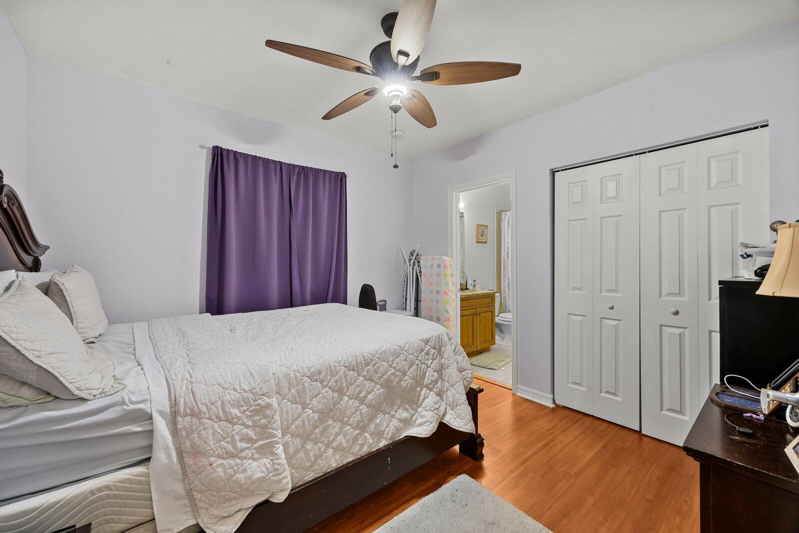 1955 Alamanda Way Riviera Beach, FL 33404 - Photo 14 of 25 a bed room with a bed and a ceiling fan