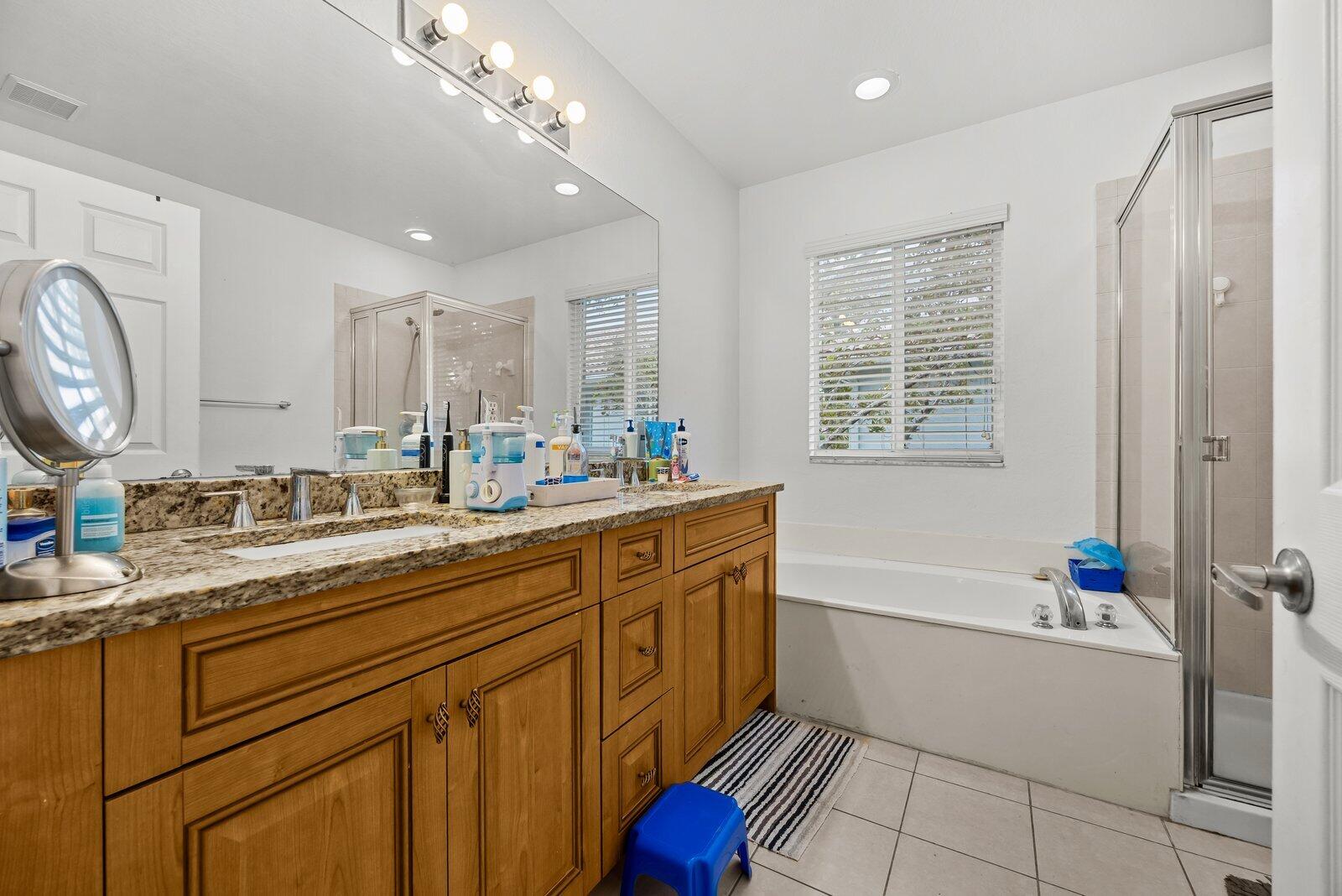 1955 Alamanda Way Riviera Beach, FL 33404 - Photo 16 of 25 a bathroom with a tub sink and mirror