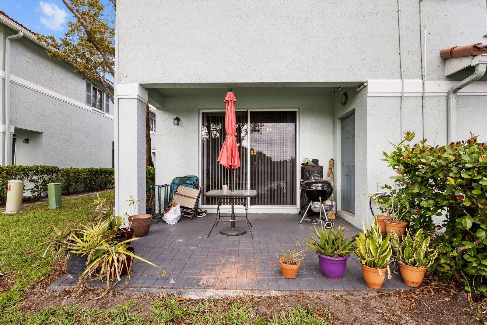 1955 Alamanda Way Riviera Beach, FL 33404 - Photo 20 of 25 a view of the patio with table and chairs potted plants