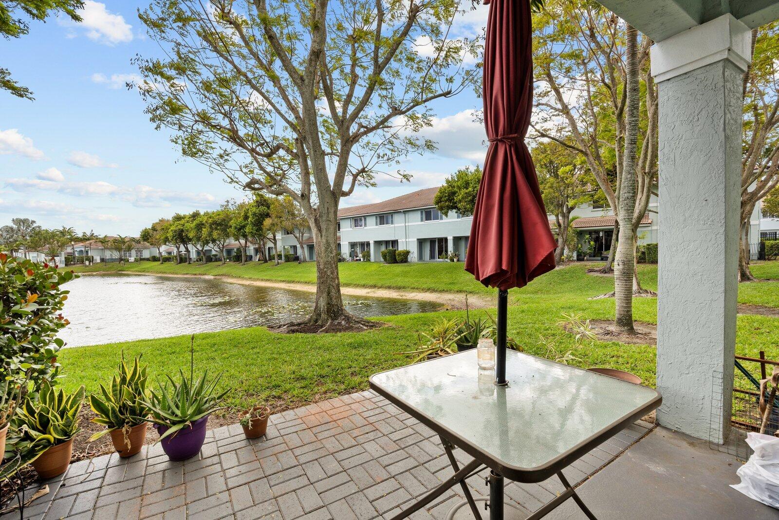 1955 Alamanda Way Riviera Beach, FL 33404 - Photo 21 of 25 a view of a house with garden and lake view