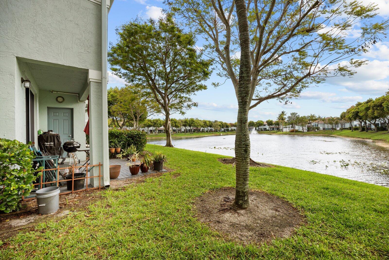 1955 Alamanda Way Riviera Beach, FL 33404 - Photo 24 of 25 a view of a lake with a garden and trees