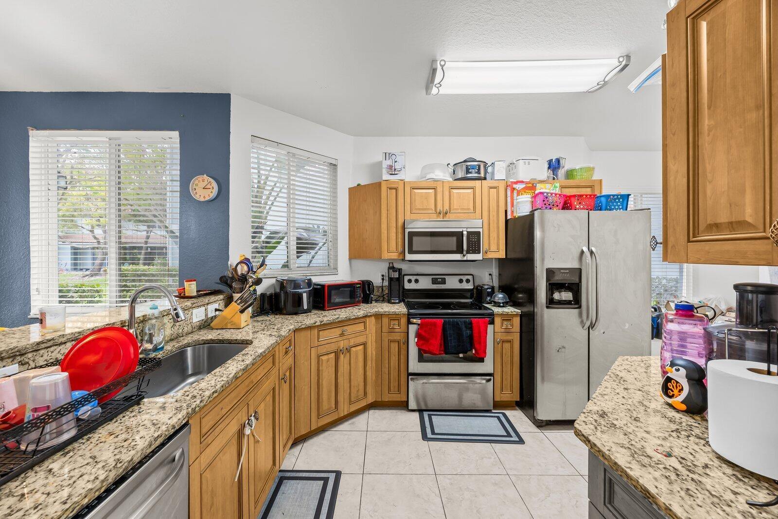 1955 Alamanda Way Riviera Beach, FL 33404 - Photo 5 of 25 a kitchen with granite countertop a sink appliances and cabinets